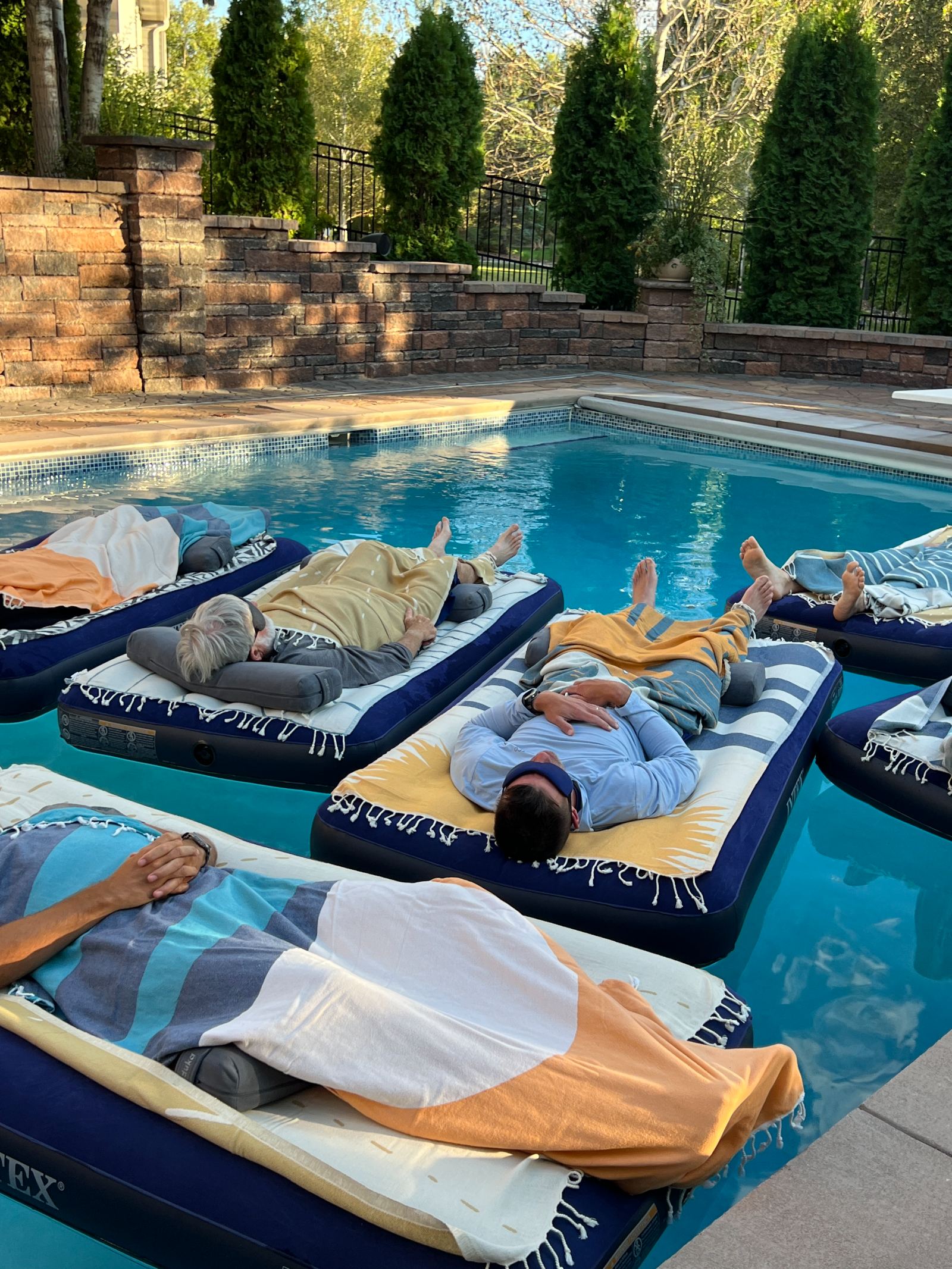 A group sound bath event on pool floats